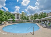 Thumbnail 17 of 39 - Apartments In Houston Texas for Rent – Westchase Forest - Photo of a swimming pool with chairs and umbrellas