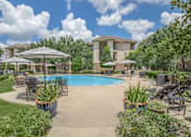 Thumbnail 18 of 39 - Affordable Houston Texas Apartments – Westchase Forest – Photo of a swimming pool with patio furniture and umbrellas