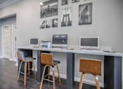 Thumbnail 26 of 39 - Apartments In Houston Texas for Rent – Westchase Forest - Photo of a long desk with three computers and three stools