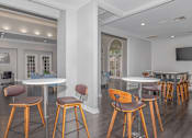 Thumbnail 28 of 39 - Pet-Friendly Apartments in Houston, TX – Westchase Forest – Photo of a community room with tables and chairs and a tv