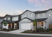 Thumbnail 27 of 31 - a gray house with a white garage door on a sidewalk