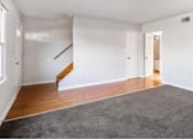 Thumbnail 7 of 13 - A room with a grey carpet and wooden floors.