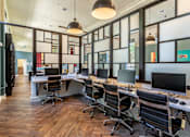 Thumbnail 28 of 39 - A modern office with wood floors and glass walls.