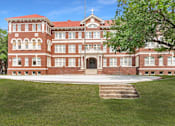 Thumbnail 31 of 39 - A large red brick building with a cross on top of it.