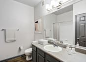 Thumbnail 9 of 18 - Parc at Metro Center Apartments near Salemtown, TN photo of a bathroom with a mirror and a sink and a toilet