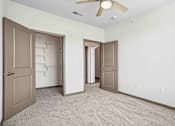 Thumbnail 18 of 33 - A room with a ceiling fan and carpeted floor.