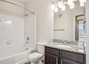Thumbnail 20 of 33 - Pet-Friendly Rentals in Bentonville, AR – Parc at Bentonville – A white bathroom with a toilet, sink, and bathtub.