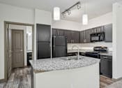 Thumbnail 14 of 33 - Pet-Friendly Rentals in Bentonville, AR – Parc at Bentonville – A kitchen with black appliances and a granite countertop.