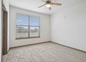 Thumbnail 19 of 33 - 1 & 2-Bedroom Apartments for Rent in Bentonville, AR – Parc at Bentonville – A room with a ceiling fan and a window with blinds.