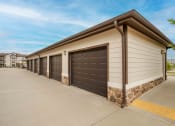 Thumbnail 32 of 33 - Pet-Friendly Rentals in Bentonville, AR – Parc at Bentonville – a row of garages in front of a building