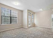 Thumbnail 11 of 25 - Pet-Friendly Rentals in Maumelle, AR – Parc at Maumelle – A room with a carpeted floor, a window with blinds, and a door with a window.