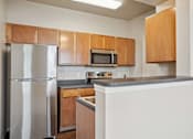 Thumbnail 5 of 25 - Pet-Friendly Rentals in Maumelle, AR – Parc at Maumelle – A kitchen with a refrigerator, microwave, and countertop.