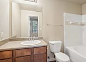 Thumbnail 12 of 25 - A bathroom with a white toilet and a white sink.