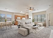 Thumbnail 1 of 25 - A living room with a white couch and a wooden dining table.