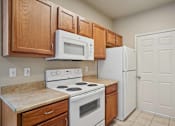 Thumbnail 5 of 25 - A kitchen with a white stove and white refrigerator.