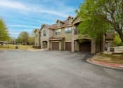 Thumbnail 23 of 25 - apartment building with a drive way in the front and garages