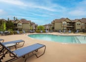 Thumbnail 12 of 25 - Swimming pool surrounded by apartments and beach chairs