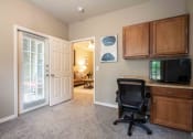 Thumbnail 15 of 25 - Parc at Rogers room with a desk and chair and cabinets and carpet and doors