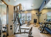 Thumbnail 13 of 25 - gym with lifting and cardio equipment with a big mirror and windows