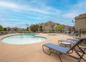 Thumbnail 2 of 25 - Swimming pool surrounded by apartments and beach chairs