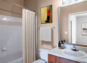 Thumbnail 14 of 25 - a bathroom with a shower and a sink and a toilet