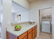 Thumbnail 12 of 25 - a kitchen with a sink and a washer and dryer and a laundry room