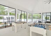 Thumbnail 18 of 28 - Omnia at Richmond Hill Townhomes in Georgia photo of a large room with a foosball table and games