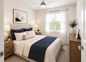 Thumbnail 3 of 14 - A bedroom with a bed, nightstand, and a ceiling fan.