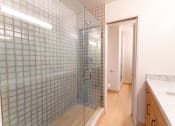 Thumbnail 9 of 29 - a bathroom with blue tiles and a glass shower door