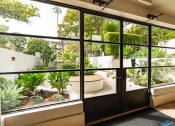 Thumbnail 13 of 29 - Apartments in Santa Monica, CA for Rent - San Vicente Tower - Lush Courtyard, with Green Plantbeds, Trees, Hedges, and Wooden-Topped Seating Area