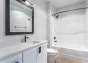 Thumbnail 12 of 42 - a bathroom with white fixtures and a white toilet next to a white bathtub with a shower