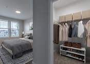 Thumbnail 9 of 42 - One BR Apartments in Sherwood OR - Cannery Row - Bedroom with Carpeted Floor, Bed, Wall Art, Windows with Blinds, and Walk-In Closet