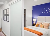 Thumbnail 12 of 43 - a bedroom with a bed and a blue wall