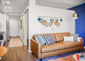 Thumbnail 13 of 43 - a living room with a leather couch and a blue accent wall