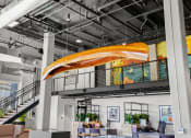 Thumbnail 14 of 43 - the lobby of a building with a large orange slide in the ceiling