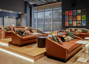 Thumbnail 26 of 43 - a living room with couches and tables and a large window