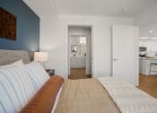 Thumbnail 6 of 43 - a bedroom with a couch and a view of the kitchen and living room
