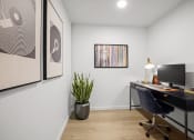 Thumbnail 7 of 43 - a home office with a desk and a monitor and a plant