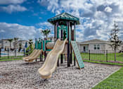 Thumbnail 9 of 36 - A playground with a green slide and a wooden slide.