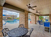 Thumbnail 31 of 33 - Relaxing area near pool with tables and chairs and fan
