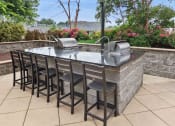 Thumbnail 18 of 38 - outdoor kitchen with stainless steel grills and bar seating
