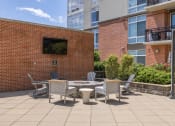 Thumbnail 27 of 38 - a patio with a table and chairs in front of a building