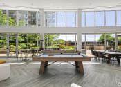 Thumbnail 10 of 38 - a pool table in a living room with large windows