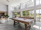 Thumbnail 9 of 25 - A pool table in a room with a view of the city.