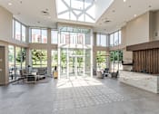Thumbnail 21 of 25 - A spacious lobby with a skylight and a reception desk.