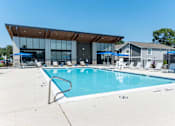 Thumbnail 13 of 28 - A large swimming pool with a building in the background.