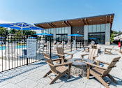 Thumbnail 16 of 28 - A pool area with chairs and a sign that says "FREE PARKING".