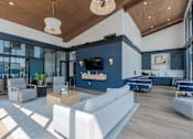 Thumbnail 18 of 28 - A spacious living room with a white sofa set and a wooden ceiling.