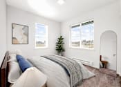 Thumbnail 4 of 26 - A bedroom with a large bed and a small tree in the corner.