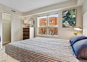 Thumbnail 16 of 27 - A bedroom with a large bed and a window overlooking a brick building.
